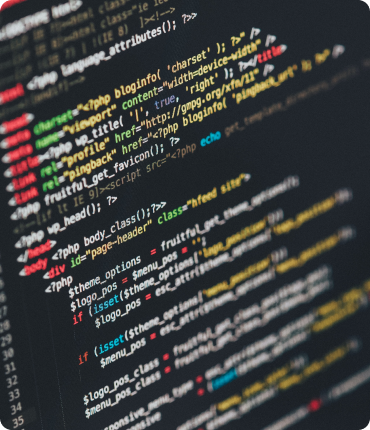 Close-up of a computer screen displaying HTML and PHP code—this digital solution features syntax and structure in vivid red, yellow, blue, and green. The colorful tags and functions lay the foundation for creating an enhanced customer experience through custom software development.