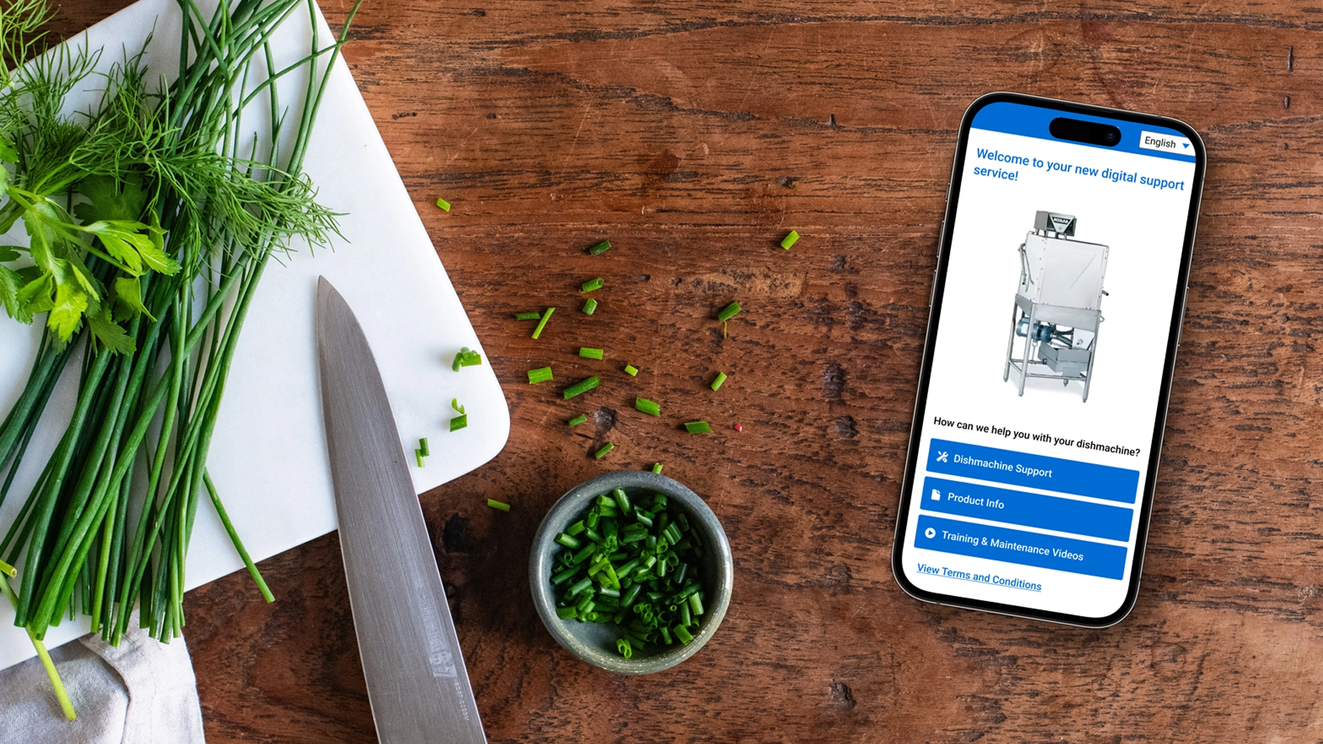 Mobile device is placed on a wooden work top next to a cutting board and knife with fresh cut herbs. The screen displays the customer experience for product information and support for a dishmachine.