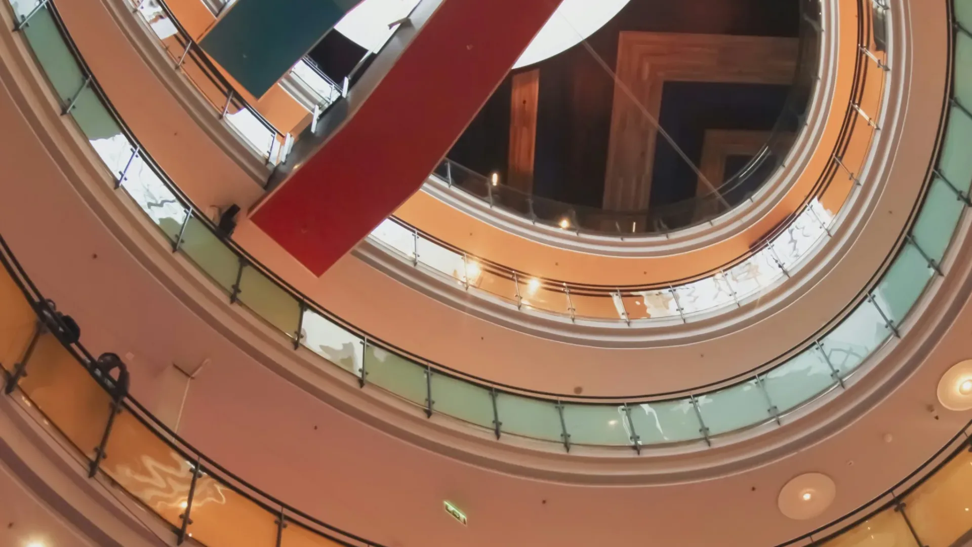 View of a shopping center atrium from the ground level. Multiple floors and bridges in view representing customer journey-centric design.